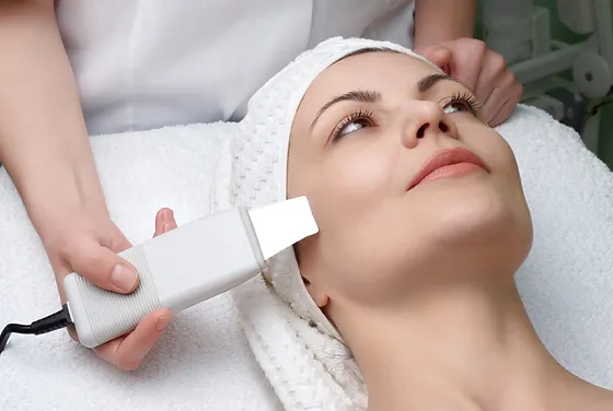 Woman receiving a facial skin treatment with a skincare device.