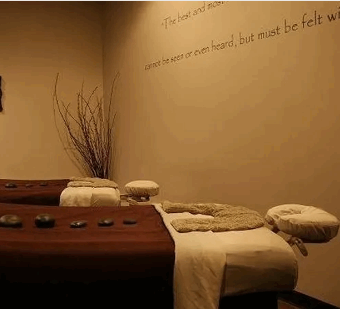 Massage therapy room with stones laying on top of two tables
