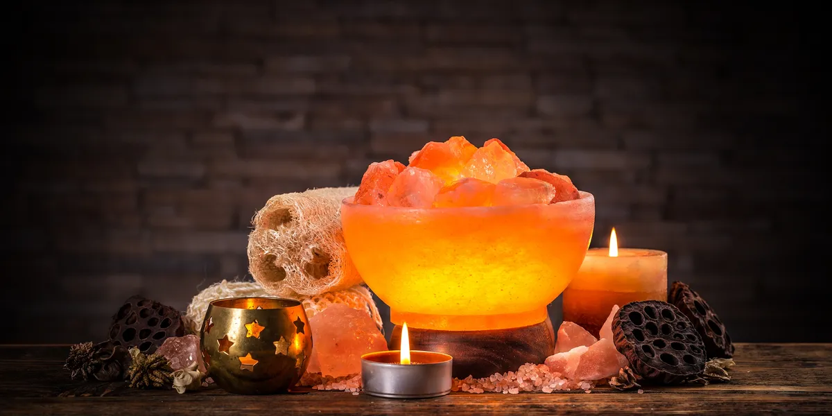 Warm, glowing salt lamp and candles