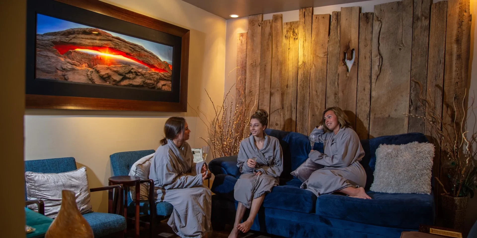 Three people in robes, chatting indoors.